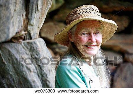 Senior woman with straw hat looking into camera View Large Photo Image Stock Image - Senior woman with straw hat looking into camera. Fotosearch