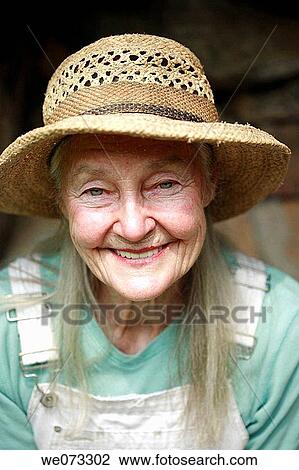 Stock Image - Senior woman with straw hat looking into camera. Fotosearch