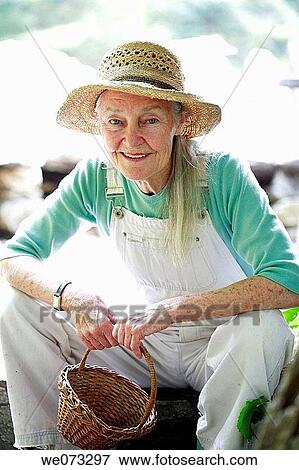 Senior woman with straw hat looking into camera with basket View Large Photo Image Stock Photo - Senior woman with straw hat looking into camera with basket. Fotosearch