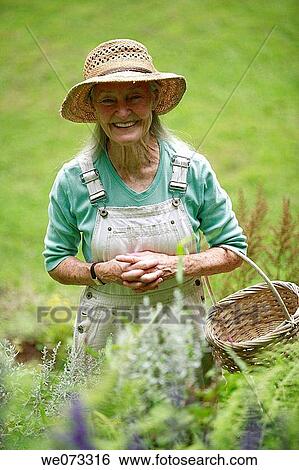 Senior woman with straw hat looking into camera with basket View Large Photo Image Stock Photograph - Senior woman with straw hat looking into camera with basket. Fotosearch