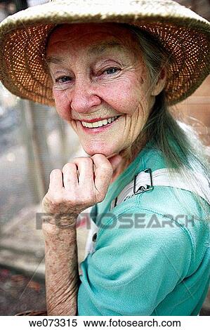 Stock Photography - Senior woman with straw hat looking into camera. Fotosearch