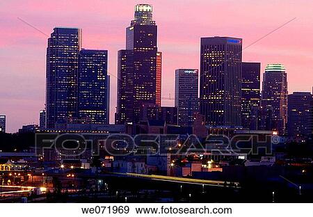 Skyscrapers light up as the sun goes down in Los Angeles, California, USA at dusk. Commuter railroad blur in the foreground. View Large Photo Image Stock Photo - Skyscrapers light up as the sun goes down in Los Angeles, California, USA at dusk. Commuter railroad blur in the foreground.. Fotosearch