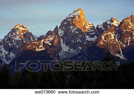 The first light of day colors the tops of the Grand Teton Mountains, Grand Teton National Park. Wyoming, USA View Large Photo Image Stock Image - The first light of day colors the tops of the Grand Teton Mountains, Grand Teton National Park. Wyoming, USA. Fotosearch