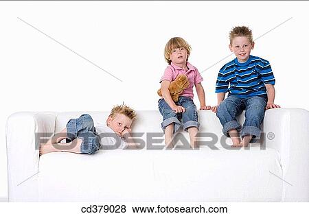 Three boys sitting on a bench View Large Photo Image Stock Photo - Three boys sitting on a bench. Fotosearch