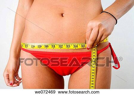 Torso shot of young woman in red bikini measuring her hips. View Large Photo Image Stock Photo - Torso shot of young woman in red bikini measuring her hips.. Fotosearch