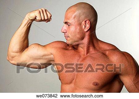 Tough strong man in his 30s pumping his biceps View Large Photo Image Stock Image - Tough strong man in his 30s pumping his biceps. Fotosearch