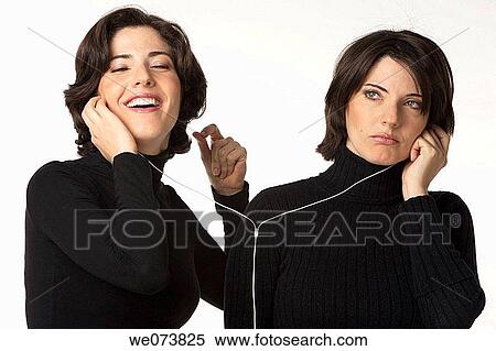 Stock Photography - Twin sisters listening to music: one happy the other one upset. Fotosearch