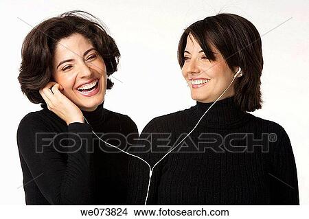 Twin sisters listening to music View Large Photo Image Picture - Twin sisters listening to music. Fotosearch