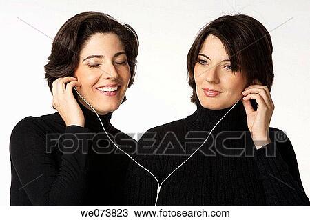 Twin sisters listening to music View Large Photo Image Stock Image - Twin sisters listening to music. Fotosearch