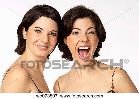 Twin sisters looking at the camera: one smiles while the other one screams View Large Photo Image Stock Photo - Twin sisters looking at the camera: one smiles while the other one screams. Fotosearch