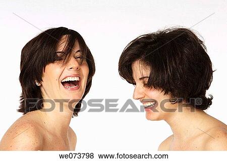 Twin sisters share a laugh in a studio setting View Large Photo Image Stock Photo - Twin sisters share a laugh in a studio setting. Fotosearch