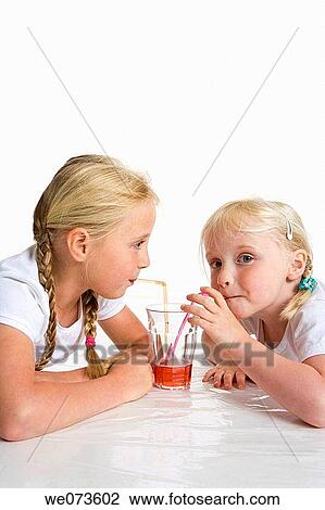 Two blond girls drinking lemonade with a straw View Large Photo Image Stock Image - Two blond girls drinking lemonade with a straw. Fotosearch