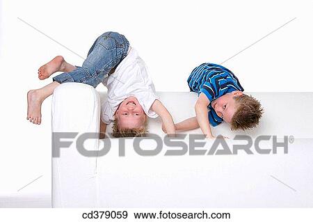 Two boys climbing on a bench View Large Photo Image Stock Photo - Two boys climbing on a bench. Fotosearch