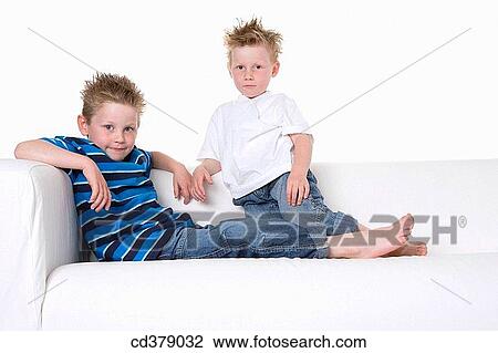 Two boys sitting on a bench View Large Photo Image Stock Image - Two boys sitting on a bench. Fotosearch