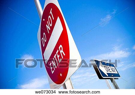 Two traffic signs reading? One Way? and? Do Not Enter? near a city street. View Large Photo Image Picture - Two traffic signs reading? One Way? and? Do Not Enter? near a city street.. Fotosearch