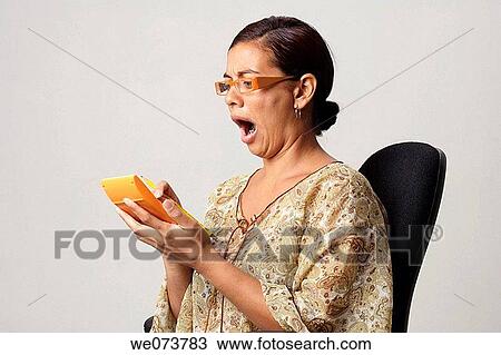 Woman in her 30s with retro sunglasses panics after watching the figures on her calculator View Large Photo Image Stock Image - Woman in her 30s with retro sunglasses panics after watching the figures on her calculator. Fotosearch