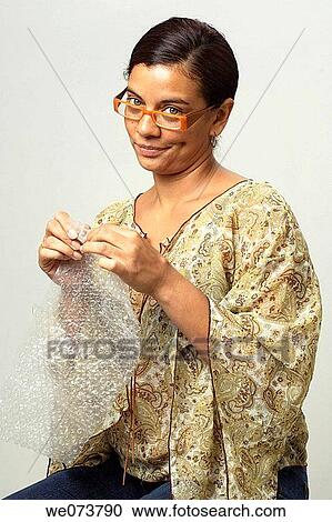 Woman in her 30s with retro sunglasses plays with bubble pack View Large Photo Image Stock Image - Woman in her 30s with retro sunglasses plays with bubble pack. Fotosearch