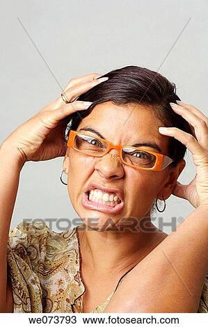 Woman in her 30s with retro sunglasses grabs her head in desperation View Large Photo Image Stock Image - Woman in her 30s with retro sunglasses grabs her head in desperation. Fotosearch