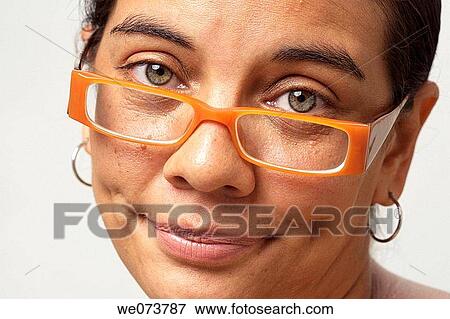 Stock Photo - Woman in her 30s with retro sunglasses looks sad at the camera. Fotosearch