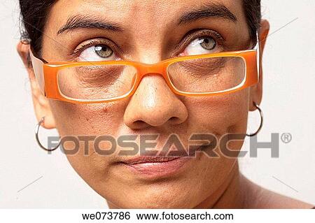 Stock Photograph - Woman in her 30s with retro sunglasses looks up. Fotosearch