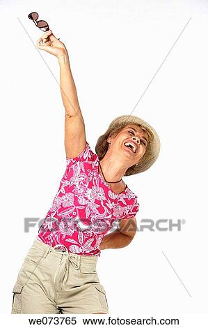 Woman in her 60s plays with sunglasses in a studio setting View Large Photo Image Stock Photography - Woman in her 60s plays with sunglasses in a studio setting. Fotosearch