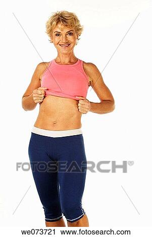 Woman in her 60s shows her flat stomach View Large Photo Image Stock Image - Woman in her 60s shows her flat stomach. Fotosearch
