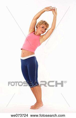 Woman in her 60s stretches in a studio setting View Large Photo Image Picture - Woman in her 60s stretches in a studio setting. Fotosearch