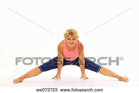 Woman in her 60s stretches in a studio setting View Large Photo Image Stock Image - Woman in her 60s stretches in a studio setting. Fotosearch
