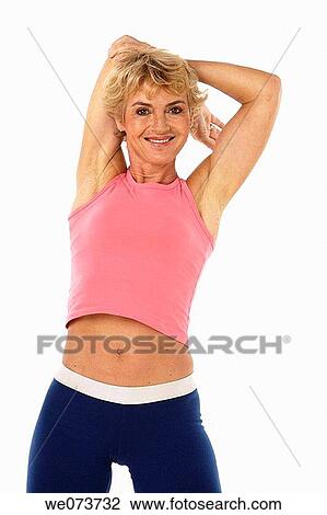 Woman in her 60s stretches in a studio setting View Large Photo Image Stock Image - Woman in her 60s stretches in a studio setting. Fotosearch