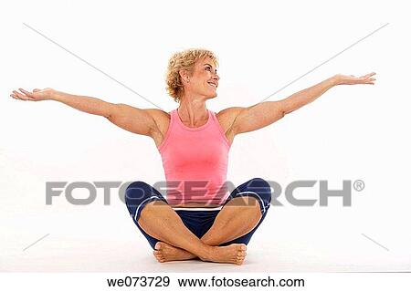 Woman in her 60s stretches in a studio setting View Large Photo Image Stock Photo - Woman in her 60s stretches in a studio setting. Fotosearch
