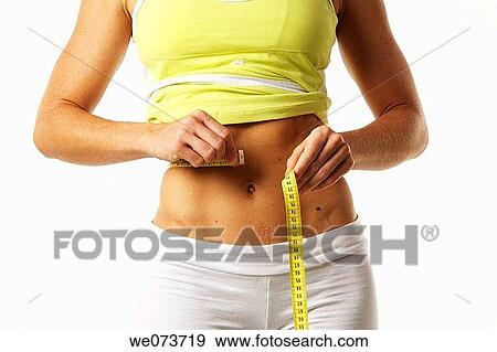 Woman in her late 20s measures her flat stomach View Large Photo Image Stock Photo - Woman in her late 20s measures her flat stomach. Fotosearch