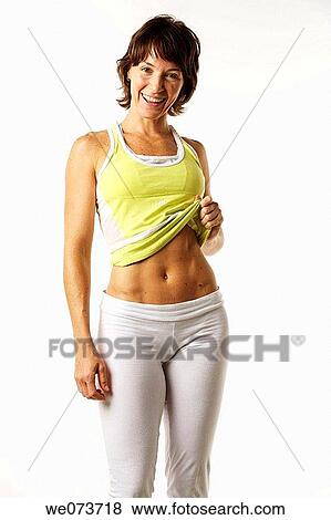 Woman in her late 20s shows her flat stomach View Large Photo Image Stock Photo - Woman in her late 20s shows her flat stomach. Fotosearch