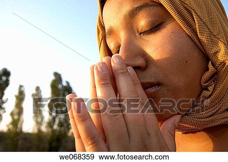 Woman praying wearing a? hijab? (a veil - from the Arabic word? hajaba? - to cover) View Large Photo Image Stock Photo - Woman praying wearing a? hijab? (a veil - from the Arabic word? hajaba? - to cover). Fotosearch