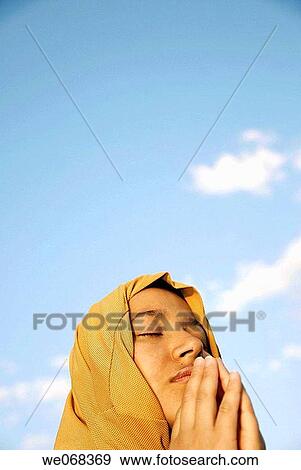 Woman praying wearing a? hijab? (a veil - from the Arabic word? hajaba? - to cover) View Large Photo Image Stock Photo - Woman praying wearing a? hijab? (a veil - from the Arabic word? hajaba? - to cover). Fotosearch