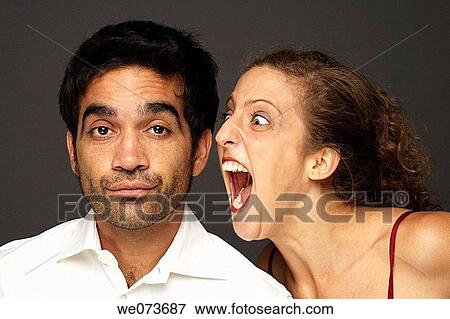 Stock Photo - Woman screaming at a man while he doesn? t seem to care or listen. Fotosearch