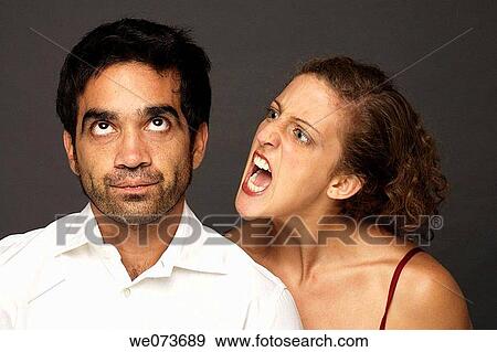 Stock Photo - Woman screaming at a man while he doesn? t seem to care or listen. Fotosearch