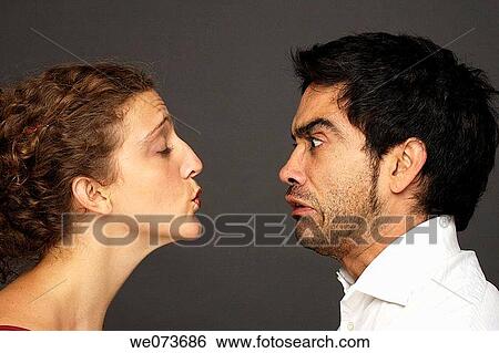 Woman tries to kiss a man while he reacts in disgust View Large Photo Image Stock Photograph - Woman tries to kiss a man while he reacts in disgust. Fotosearch