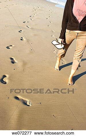 Stock Photo - Woman walking on beach, San Juan Beach, Alicante. Fotosearch