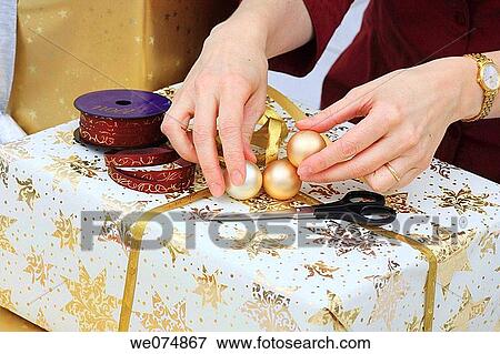 Woman wrapping up Christmas present, Christmas gift View Large Photo Image Stock Photo - Woman wrapping up Christmas present, Christmas gift. Fotosearch