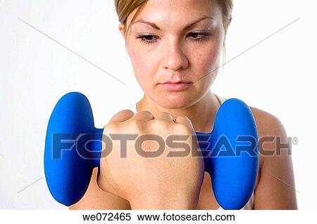 Young blond woman focuses on lifting weight during her workout. View Large Photo Image Stock Photography - Young blond woman focuses on lifting weight during her workout.. Fotosearch