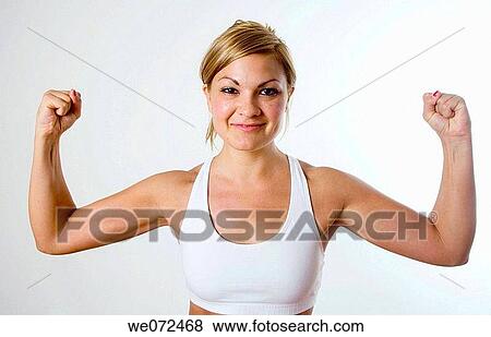 Young blond woman in workout gear happily flexes her muscles. View Large Photo Image Stock Photo - Young blond woman in workout gear happily flexes her muscles.. Fotosearch