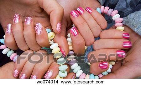 Picture - Young girls hands with painted nails and sweet necklace. Fotosearch