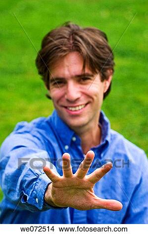 Young man pointing his hand towards the camera View Large Photo Image Picture - Young man pointing his hand towards the camera. Fotosearch