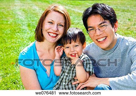 Stock Image - Young white woman and her Asian husband with their toddler Eurasian son.. Fotosearch