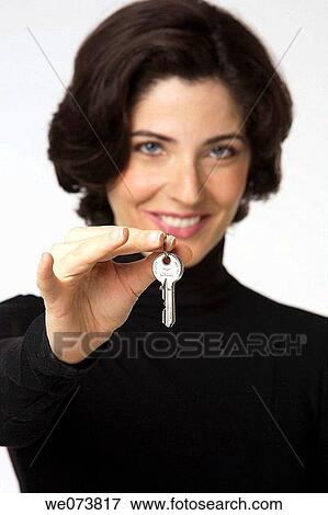 Young woman in her 30s offfering a key View Large Photo Image Stock Photo - Young woman in her 30s offfering a key. Fotosearch