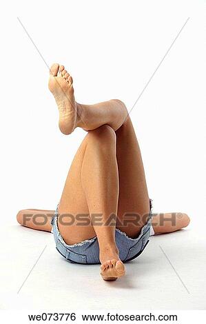Young woman lies feet up in a studio setting View Large Photo Image Stock Photograph - Young woman lies feet up in a studio setting. Fotosearch