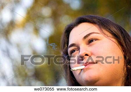 Young woman smoking a cigarette. View Large Photo Image Stock Photography - Young woman smoking a cigarette.. Fotosearch
