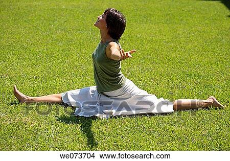 Young woman stretching on grass View Large Photo Image Picture - Young woman stretching on grass. Fotosearch
