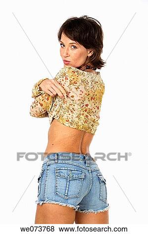 Young woman takes her shirt off in a studio setting View Large Photo Image Stock Photo - Young woman takes her shirt off in a studio setting. Fotosearch