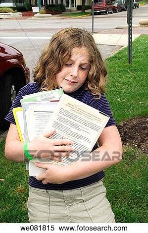 11-year-old girl holding too many library books, about to drop some, on street in Bloomington, Indiana, USA View Large Photo Image Stock Photography - 11-year-old girl holding too many library books, about to drop some, on street in Bloomington, Indiana, USA. Fotosearch